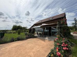 a house with a garden and a building with flowers at Gite de la roseraie in Louchy-Montfand