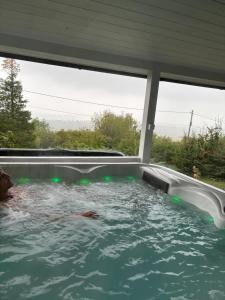 a person swimming in a hot tub in a house at Szarvas Vendégház in Zebegény