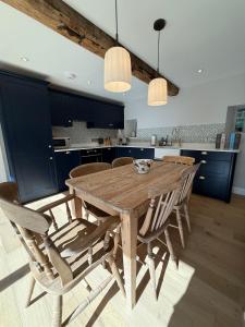 a wooden table and chairs in a kitchen at Recently converted barn on the outskirts of Bath in Radstock