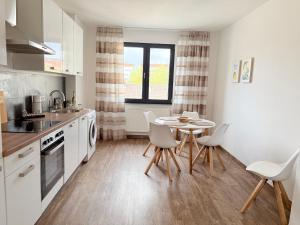 een keuken met een tafel en stoelen in een kamer bij BIELEFELD CITY APARTMENTS - Cozy in Bielefeld