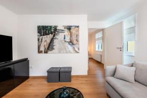 a living room with a couch and a painting on the wall at The Cozy Corner - Passau in Passau