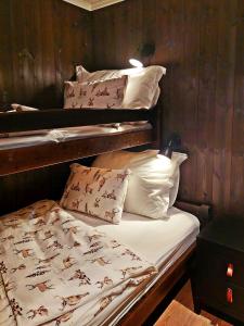 a bedroom with two bunk beds with pillows at Modern Mountain Cabin With A View Over The Sea in Vevle