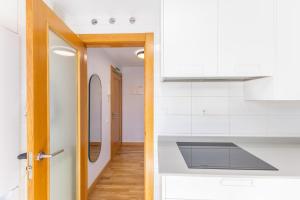 a kitchen with white cabinets and a door at Holidea Liencres in Liencres