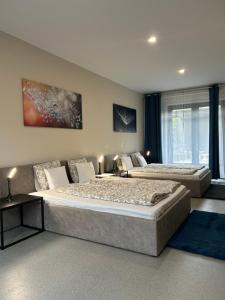 une chambre avec deux lits et un canapé dans l'établissement 4 hálószobás Pihenj Meg Vendégház, à Nyíregyháza