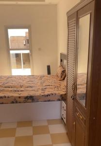 ein Schlafzimmer mit einem Bett und einem großen Fenster in der Unterkunft Nord foire studio meublé à Dakar in Dakar