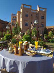a table with food on it in front of a building at Palm Dades in Boumalne