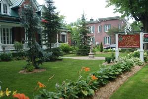 a yard with a sign in front of a house at La Belle aux Berges in Saint-Denis-sur-Richelieu