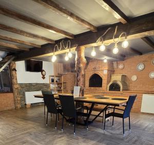 a dining room with a wooden table and chairs at Pensiunea El Monte SPA in Rucăr