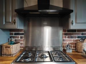 un four à plaques de cuisson dans une cuisine avec des paniers dans l'établissement La Tometterie - longère normande traditionnelle, à Chanteloup