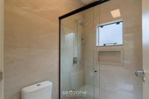 a shower in a bathroom with a toilet and a window at Casa c/ Lareira e Banheira em Urubici CLA0000 in Urubici +7 photos