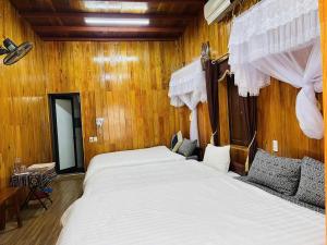 ein Schlafzimmer mit einem großen Bett mit weißer Bettwäsche in der Unterkunft homstay tuấn thơm in Mèo Vạc