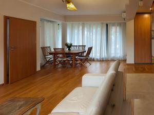 a living room with a couch and a table and chairs at Costa del Sol Apartment in Saulkrasti