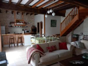 a living room with a couch and a kitchen at Le prieuré in Raslay