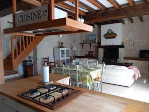 a kitchen and living room with a stove top at Le prieuré in Raslay