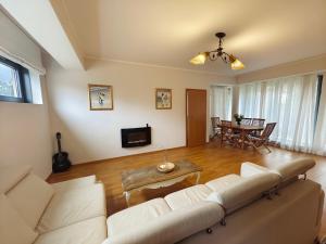 a living room with a white couch and a table at Costa del Sol Apartment in Saulkrasti