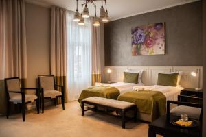 a hotel room with two beds and a table and chairs at Hirscher 14 in Braşov