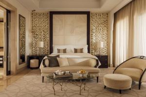 a bedroom with a bed and a couch and a table at One&Only The Palm Dubai in Dubai