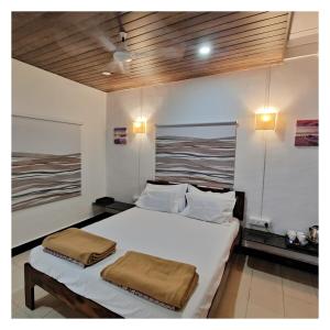 a bedroom with a bed with two pillows on it at Saraswati Vinayak Villa in Dapoli, Konkan in Dapoli