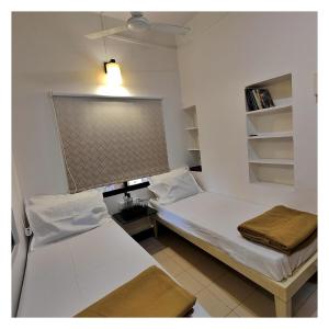 two beds in a small room with a window at Saraswati Vinayak Villa in Dapoli, Konkan in Dapoli +5 photos