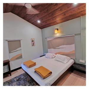 a bedroom with a bed with two towels on it at Saraswati Vinayak Villa in Dapoli, Konkan in Dapoli
