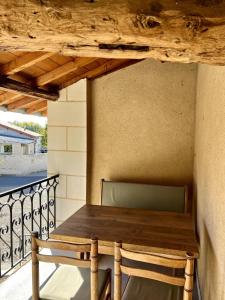 a wooden table and chairs on a balcony at L’Atelier de René Futuroscope in Beaumont +2 photos