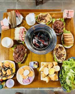 einem Holztisch mit verschiedenen Arten von Speisen in der Unterkunft homstay tuấn thơm in Mèo Vạc