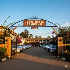 a gate to a hotel with cars parked in a parking lot at Lexus Motel Rwamwanja in Kamwenge