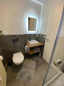 Un baño con un inodoro blanco y un lavabo. en Ferienwohnung Bächle, en Bad Peterstal