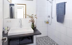 a white bathroom with a sink and a shower at KönigsSCHLAF No3 - Die Große mit Balkon in der Konstanzer Altstadt in Konstanz