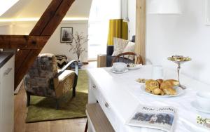 a kitchen with a table with a plate of food on it at KönigsSCHLAF No3 - Die Große mit Balkon in der Konstanzer Altstadt in Konstanz