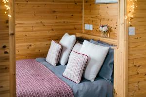 a room with a bed with four pillows at Shepherd's Huts in Barley Meadow at Spring Hill Farm in Oxford