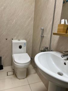 a bathroom with a white toilet and a sink at شقة Modern غرفة نوم وصالة in Al Madinah