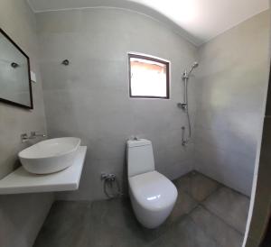 タンガラにあるNature Villaの白いトイレと洗面台のあるバスルーム +130枚の写真