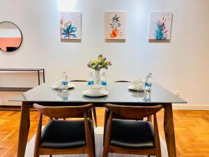 a dining room table with chairs and flowers on it at KLCC Sky Villa Suites The Mews in Kuala Lumpur