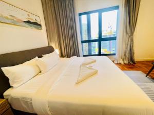 a bedroom with a large white bed with a large window at KLCC Sky Villa Suites The Mews in Kuala Lumpur +91 photos