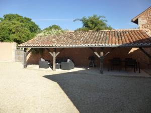 a pavilion with a table and chairs under it at Gîte du séchoir in Bouresse