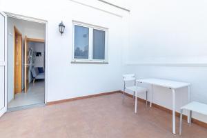 Una habitación blanca con dos mesas y una ventana. en Arinaga Playa 4, en Agüimes