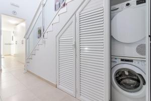 Un lavadero blanco con lavadora y secadora. en Arinaga Playa 4, en Agüimes