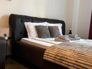 a black bed with pillows and a blanket on it at 13StudioBv in Braşov +3 photos