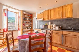 a kitchen with a table and chairs in a kitchen at Maison dans Village médiéval in Olargues +16 photos