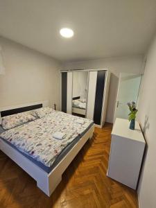 Un dormitorio con una cama y una mesa con un jarrón de flores. en Luxury Apartment Mostar Center, en Mostar