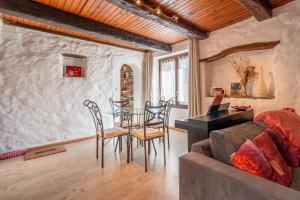 a living room with a table and chairs and a couch at Maison dans Village médiéval in Olargues