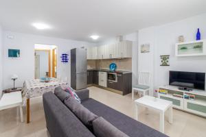 Una sala de estar con un sofá y una cocina. en Arinaga Playa 2, en Agüimes