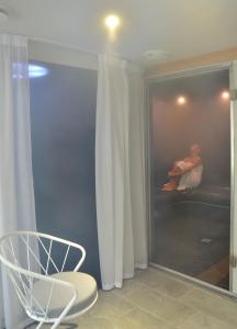 a reflection of a woman sitting on a bed in a mirror at Le Général d'Elbée Hotel & Spa - Teritoria in Noirmoutier-en-l'lle