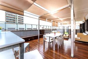 a room with tables and chairs on a balcony at Great apartment with a pool on the beach in Barcelona in Badalona