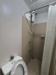 a bathroom with a toilet and a shower with a shower curtain at Prime Zen in Silang