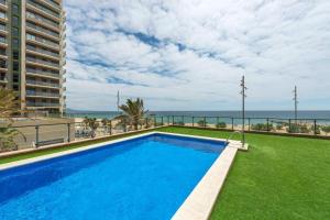 a swimming pool with a view of the ocean at Great apartment with a pool on the beach in Barcelona in Badalona