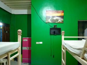 a green wall with two bunk beds in a room at Ravara Natividad Homestay in Lucap