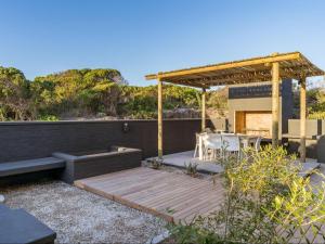 a wooden deck with a pergola and a table at Black Barn At Romansbaai in Goudiniweg