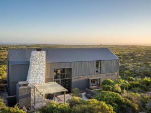 a house in the middle of a field at Black Barn At Romansbaai in Goudiniweg